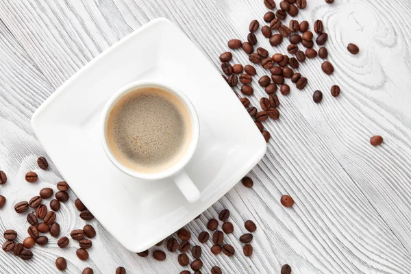 kahve kahve fasulye üzerinde beyaz ahşap arka plan, üstten görünüm