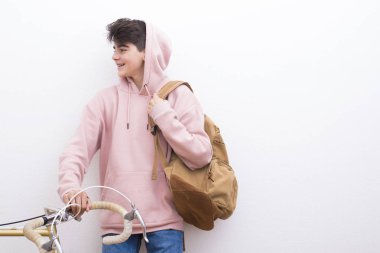 sırt çantası ve beyaz duvar üzerinde bisiklet ile genç öğrenci