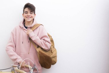 sırt çantası ve beyaz duvar üzerinde bisiklet ile genç öğrenci