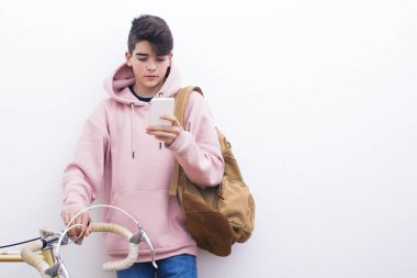 sırt çantası ve beyaz duvar üzerinde bisiklet ile genç öğrenci