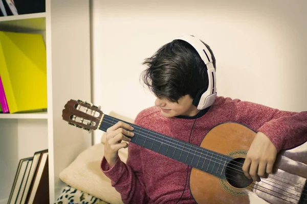 Jonge Spelen Gitaar Met Koptelefoon Thuis — Stockfoto