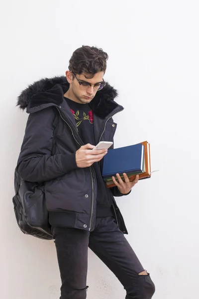 young student with mobile phone and books