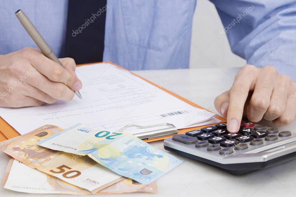 businessman with the calculator and money on the table working