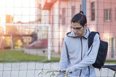 Bisiklet ve açık sırt çantası ile genç