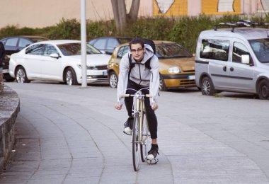 Genç adam spor yaparken şehir etrafında Bisiklete binme