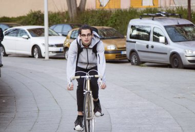 Genç adam spor yaparken şehir etrafında Bisiklete binme