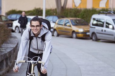 Genç adam spor yaparken şehir etrafında Bisiklete binme