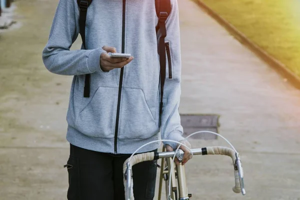 young in town with mobile phone and bike