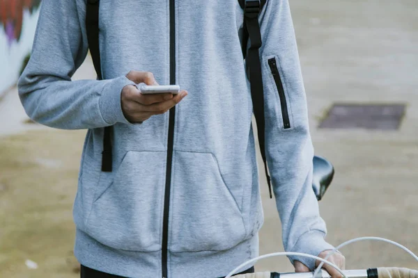 young in town with mobile phone and bike