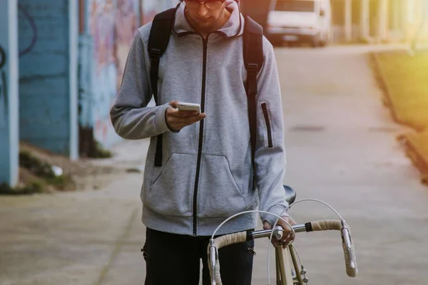 young in town with mobile phone and bike