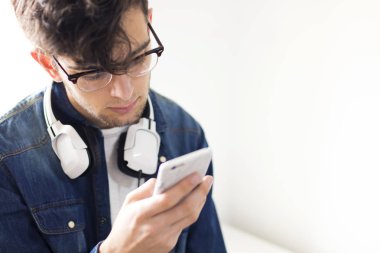 kulaklık ve cep telefonu ile genç adam