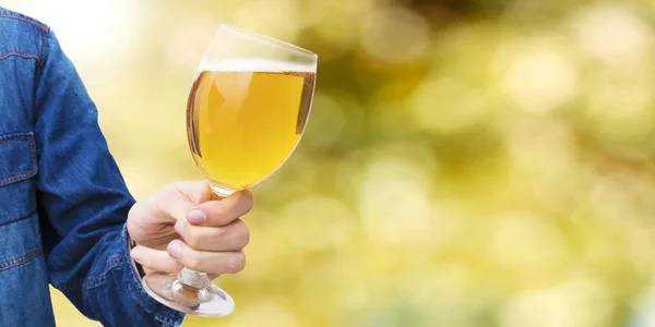 hand with beer glass and abstract background