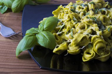 eritilmiş peynir ve fesleğen yaprağı ile tortellini makarna yemek
