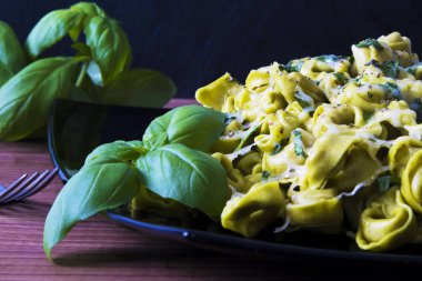 eritilmiş peynir ve fesleğen yaprağı ile tortellini makarna yemek