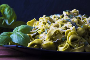 eritilmiş peynir ve fesleğen yaprağı ile tortellini makarna yemek