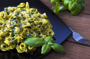 eritilmiş peynir ve fesleğen yaprağı ile tortellini makarna yemek