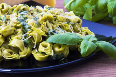 eritilmiş peynir ve fesleğen yaprağı ile tortellini makarna yemek