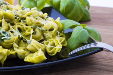 eritilmiş peynir ve fesleğen yaprağı ile tortellini makarna yemek