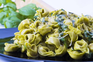 Tortellini makarna yemek sebze, peynir ve fesleğen ile