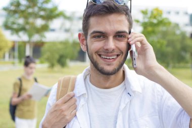 öğrenci üniversite kampüsü üstünde hareket eden telefon ile