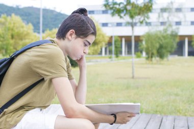 kitap sırt çantası ve defter ile genç öğrenci