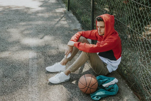 Modieuze Jonge Man Zit Het Basketbalveld — Stockfoto