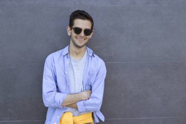 şık genç adam sokakta duvar