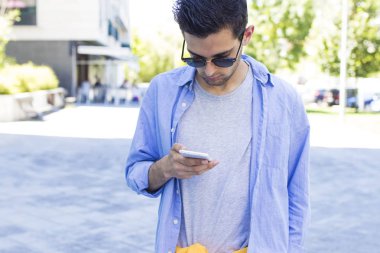 Sokakta cep telefonu olan genç bir adam.