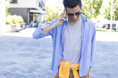 Sokakta cep telefonu olan genç bir adam.