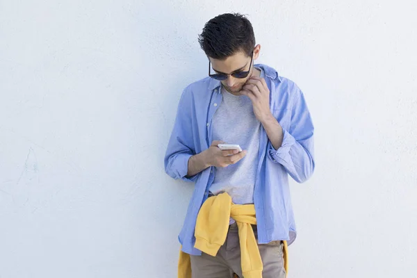 Jonge Man Met Mobiele Telefoon Aan Mode Blauwe Muur — Stockfoto