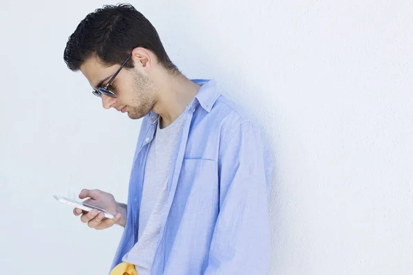 Joven Con Teléfono Móvil Pared —  Fotos de Stock