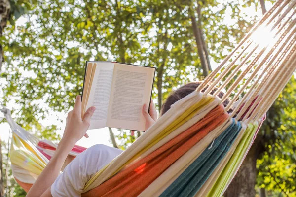 夕暮れ時開いた本とハンモックで読書 — ストック写真