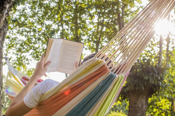 Açık kitap ile hamakta alacakaranlıkta okuma