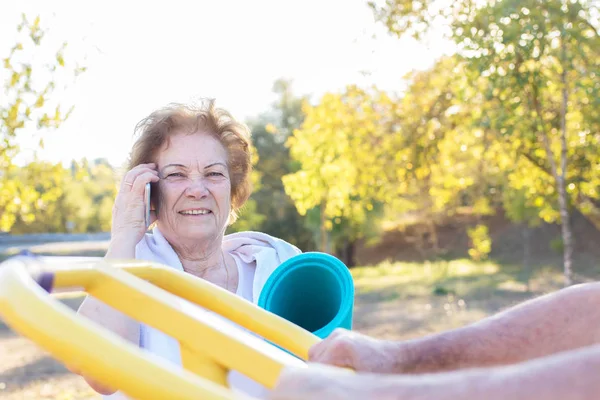 Cep Telefonu Ile Yaşlı Kadın Açık Spor Yapıyor — Stok fotoğraf