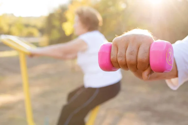 hand with gym weights and woman doing sport