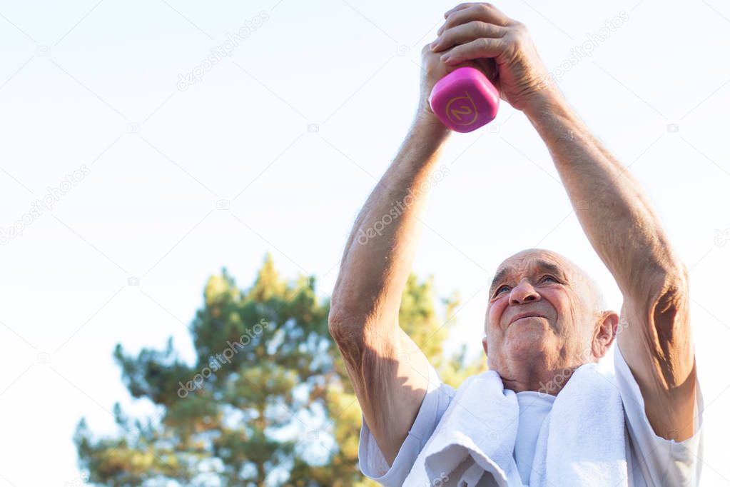 older man lifting the dumbbell exercising
