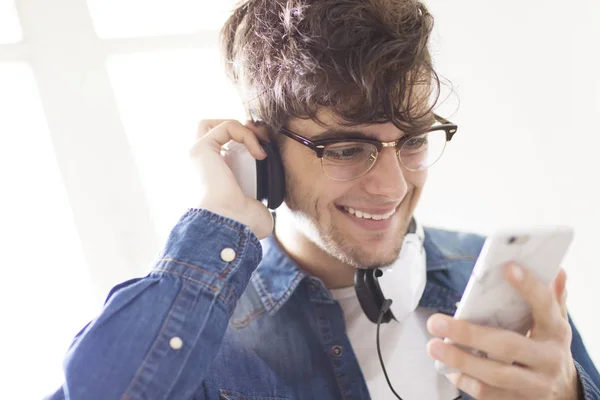 young smiling with mobile phone and fashion headphones