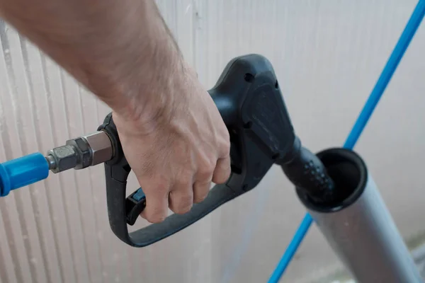 hand with hose to wash cars