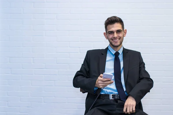 business man sitting smiling with mobile phone and background