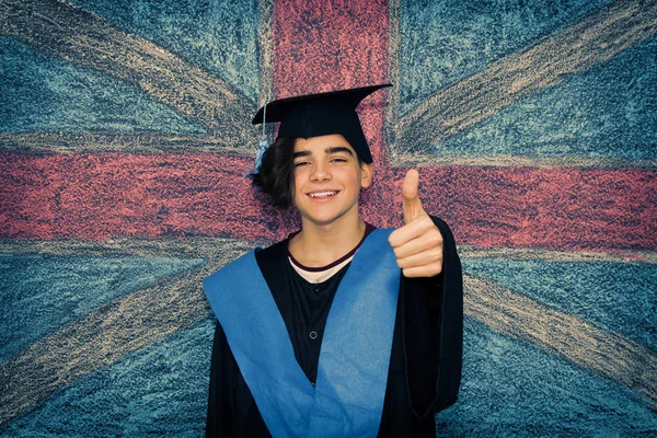 student with graduation uniform and background flag