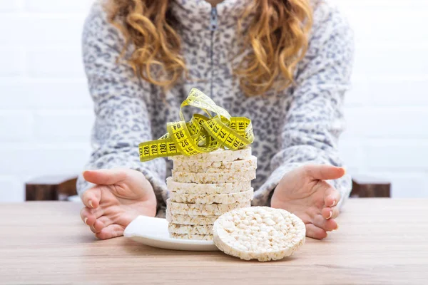 diet and slimming concept, corn cakes with tape measure and girl