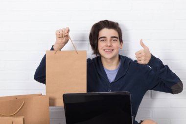 Bilgisayarlı ve alışveriş çantalı gençler, online alışverişler.