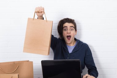 Bilgisayarlı ve alışveriş çantalı gençler, online alışverişler.
