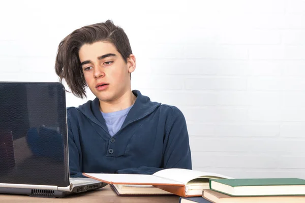 tired and bored student with computer and books