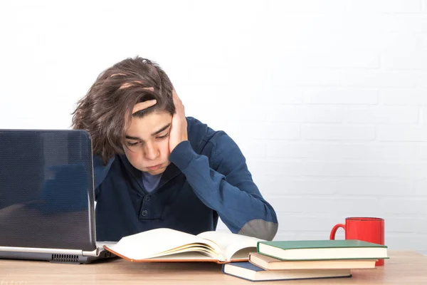 tired and bored student with computer and books
