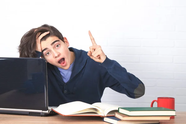 コンピュータと本を持つ疲れて退屈な学生 — ストック写真
