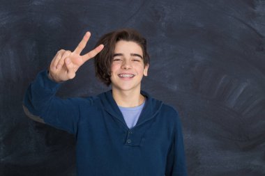 Genç adam zafer işaretiyle gülümsüyor.