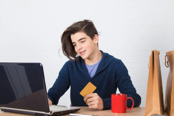 young man buying with credit card and laptop