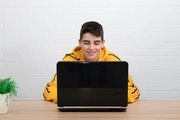 拿着电脑坐在办公桌前笑的年轻人 — 图库照片