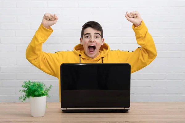 成功や勝利を祝うコンピュータを持つ若い学生は — ストック写真